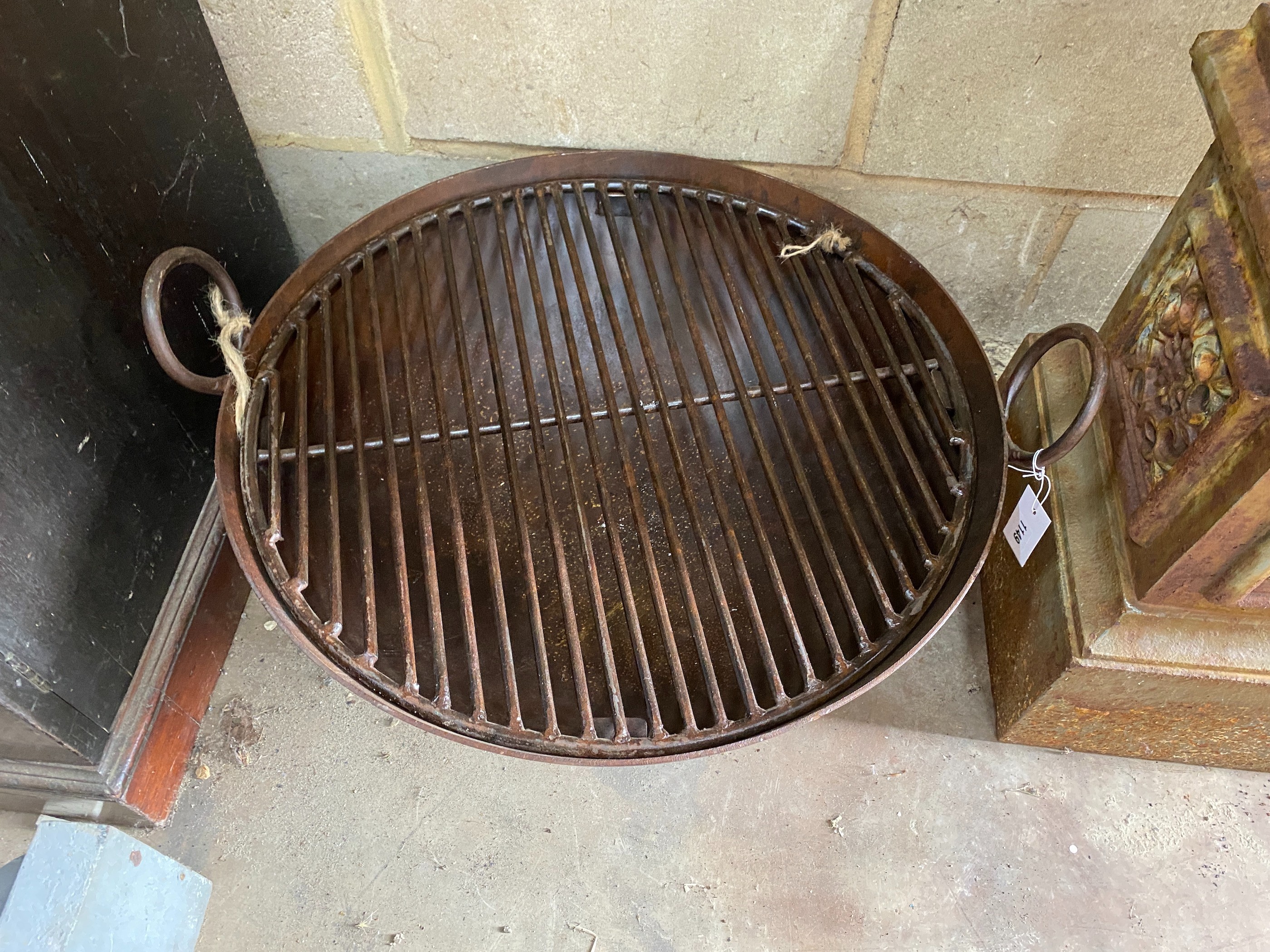 A circular wrought iron fire pit on low stand, diameter 62cm, height 37cm